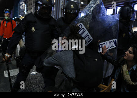 Madrid, Spagna. Xix oct, 2019. Spagnolo poliziotti antisommossa carica di un manifestante durante gli scontri.centinaia di estrema sinistra manifestanti si scontrano con la polizia dopo un rally del pacifico contro la Corte Suprema frase del catalano politica e attivisti. Essi sono stati più di dieci arresti e alcuni poliziotti sono stati feriti. In un tentativo di ricreare i violenti scontri di Barcellona i manifestanti si stabilirono barricades in alcune strade del centro citta'. Credito: Guillermo Santos SOPA/images/ZUMA filo/Alamy Live News Foto Stock