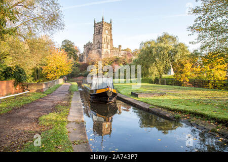 Kidderminster, Regno Unito. 30 Ott 2019. Tempo in Gran Bretagna: Dopo un inizio freddo, il terzo giorno della settimana di vacanza a metà termine delle scuole si sta rivelando una giornata di autunno gloriosamente soleggiato nel Worcestershire. La chiesa di St Mary (la chiesa parrocchiale di Kidderminster) si erge splendidamente illuminata al sole del mattino mentre una famiglia si gode una vacanza in barca a narrowboat inglese sui nostri canali britannici - visto qui vicino alla serratura di Kidderminster. Credit: Lee Hudson/Alamy Live News Foto Stock