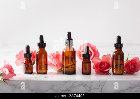 Oli essenziali in bottiglie rose fiori. medicina alternativa aromaterapia Foto Stock