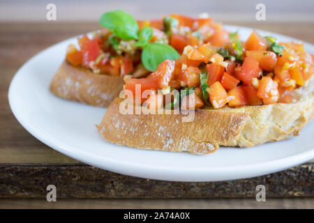 Fotografia di cibo italiano di bruschette pomodoro su una piastra bianca