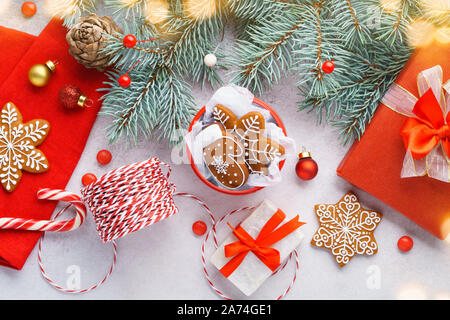 Sfondo di natale con gingerbread cookie, candy cane e decorazioni. Giallo luci di Natale, confezioni regalo. Composizione di natale. Lay piatto. Foto Stock