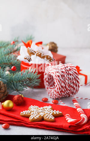 Sfondo di natale con gingerbread cookie, confezioni regalo, rosso e palline dorate, Abete rami. Copia dello spazio. Foto Stock