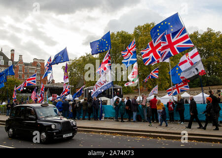 Westminster, Londra, Regno Unito. 29 ottobre, 2019. Lasciare Brexit e restano gli attivisti con UE e Union Jack Flag guarda live news la copertura delle notizie Brexit presso il College Green al di fuori della House of Commons il giorno di elezione generale è chiamato. Credito: Maureen McLean/Alamy Foto Stock