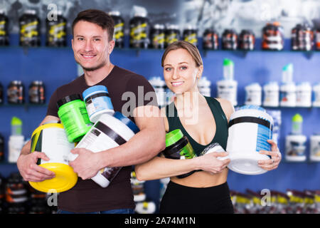 Positivo fisicamente persone azienda vaso in plastica dello sport integratori alimentari in negozio interno Foto Stock