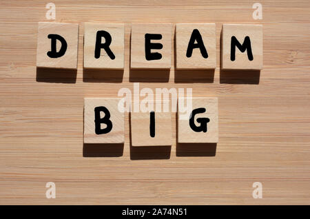Grande Sogno. Parole motivazionale in 3d alfabeto di legno lettere su un bambù Sfondo legno Foto Stock