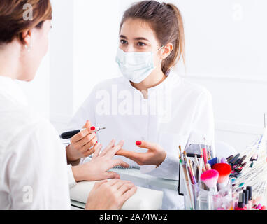 Donna cliente avente shellac manicure fatto in manicure Foto Stock