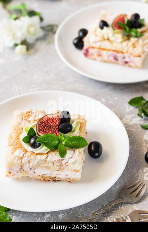 Pavlova su un biscotto con una delicata crema di cagliata, fichi e uva. Una nuova variante del classico dolce Australiano. Foto Stock