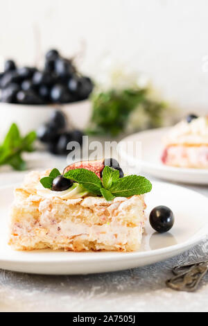 Pavlova su un biscotto con una delicata crema di cagliata, fichi e uva. Una nuova variante del classico dolce Australiano. Foto Stock