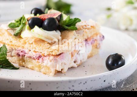 Pavlova su un biscotto con una delicata crema di cagliata, fichi e uva. Una nuova variante del classico dolce Australiano. Foto Stock