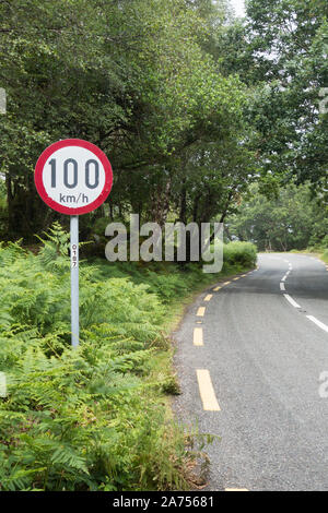 100km e ora limite di velocità su un irish country road green lane con una curva pericolosa Foto Stock