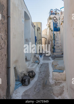 Una vista di una ombreggiatura back street in epoca medievale città Emborio village crema con accenti di color blu Santorini Foto Stock