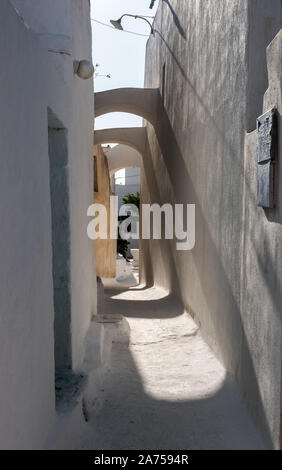 Le ombre in Emborio back street vista fino a ombreggiatura nella città medievale village Santorini Foto Stock