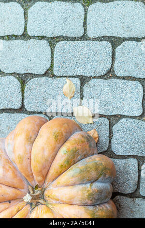 Un frammento di una grande zucca arancione sulla pietra grigia superficie Foto Stock
