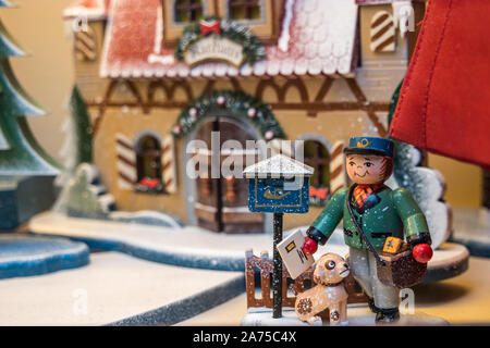 Legno giocattoli fatti a mano nella finestra di festosa store. San Nicola fuori mano doni ai bambini intorno all'albero di Natale. Foto Stock