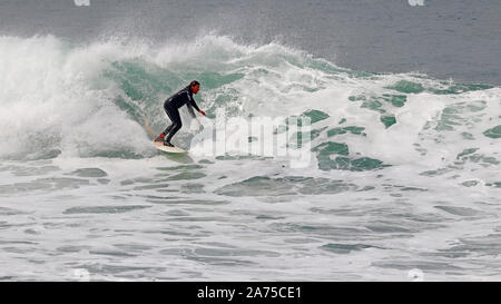 Surfer in sella a una grande onda a Fistral Beach, Newquay Cornwall. Foto Stock