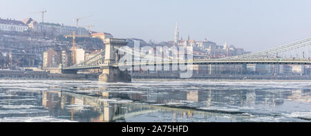 Inverno a Budapest - il famoso Ponte delle catene di Szechenyi nel centro città mentre il Danubio è parzialmente congelato e ricoperta di ghiaccio! Foto Stock