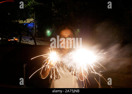 Giovane donna lo scoppio di petardi DURANTE IL DIWALI IN MUMBAI Foto Stock