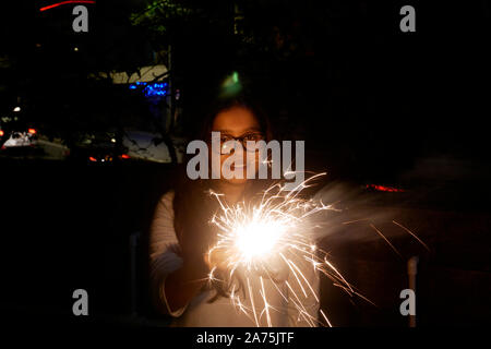 Giovane donna lo scoppio di petardi DURANTE IL DIWALI IN MUMBAI Foto Stock