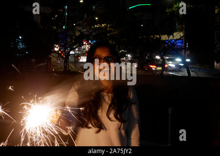 Giovane donna lo scoppio di petardi DURANTE IL DIWALI IN MUMBAI Foto Stock