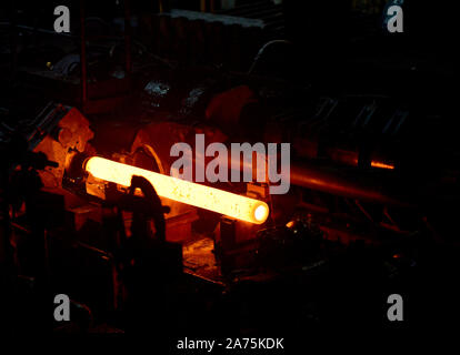 Incandescente tubo di acciaio durante la produzione in un moderno laminatoio nell'industria Foto Stock