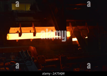 Incandescente tubo di acciaio durante la produzione in un moderno laminatoio nell'industria Foto Stock