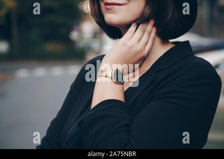 Street style 2019 Dettagli della moda. close up, moda giovane blogger che indossa jeans neri, satinata alto, blazer e un nero e golden analog orologio da polso. Foto Stock