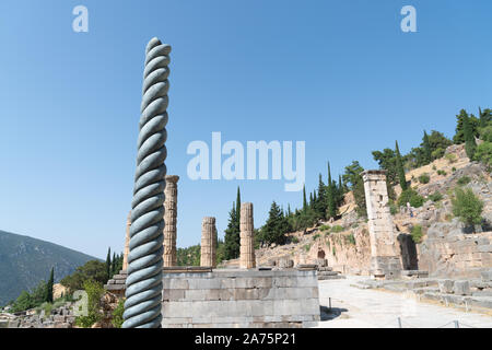 Delphi Grecia - Luglio 28 2019; antica città di Delphi rimane del serpente colonna tra le rovine e scavi con pilastri e strutture risalenti a BC Foto Stock