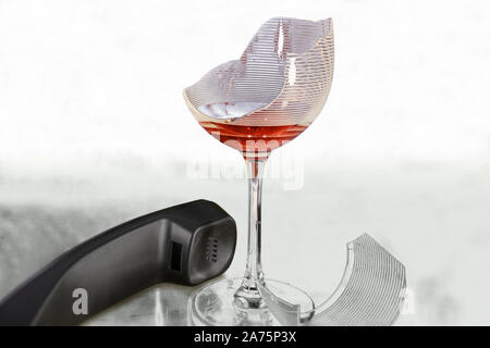 La rottura di un bicchiere di vino e un ricevitore di telefono accanto ad essa. Elevato La chiave, ad alto contrasto e copia dello spazio. Foto Stock