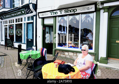 Weymouth Dorset, Regno Unito. Maggio 18, 2018. Un senior signora seduta alfresco al di fuori del negozio di T sul porto di Weymouth nel Dorset, Regno Unito. Foto Stock