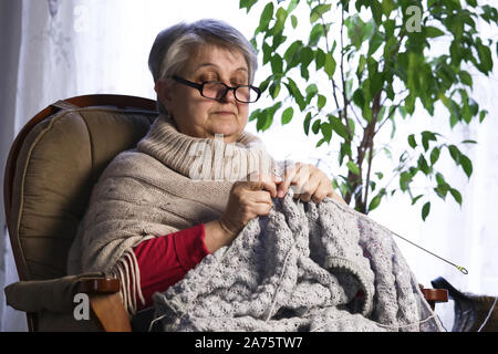 Close-up ritratto di donna Senior Maglia con lana, Nonne Mani di maglia di filo di lana. L'imbarcazione è Hobby delle donne anziane. Senior Lady, Felice Granny Knitte Foto Stock