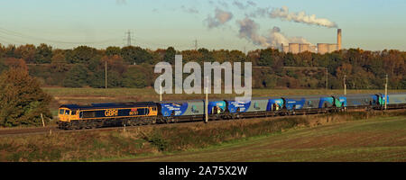 Un GBRF locomotiva diesel passa Daresbury vicino a Runcorn su un luminoso mattino d'autunno. Il treno sta portando a biomassa importata di Drax power station. Foto Stock