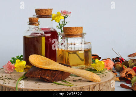 La medicina naturale: selezione di 3 bottiglie con oli essenziali con fiori selvatici e di legno cucchiaio di bambù. Medicina alternativa che rispetti l'Amb. Foto Stock