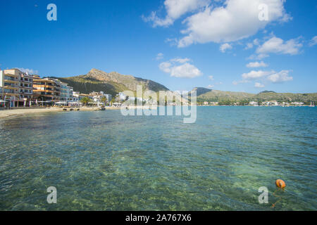 Un cristallo di bella vista d'acqua e montagne verdi sulla giornata di sole catturata da una dock a Puerto de Pollensa beach in Palma de Mallorca , Spagna Foto Stock