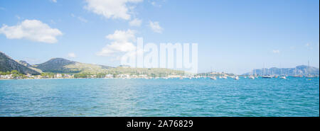 Un cristallo di bella vista d'acqua e montagne verdi sulla giornata di sole catturata da una dock a Puerto de Pollensa beach in Palma de Mallorca , Spagna Foto Stock