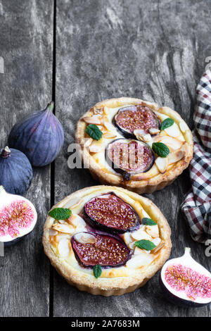 In casa la fig tartles con formaggio brie e mandorle sul tavolo di legno Foto Stock