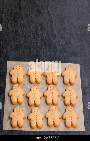 Set di cotto gingerbread man cookies sul nero lo sfondo di pietra Foto Stock
