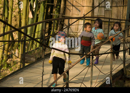 Sapa, Lao Cai, Vietnam - Marzo 21, 2011: Cute bambini piccoli di etnia Hmong camminando sul Ponte di Ta Phin Village Foto Stock