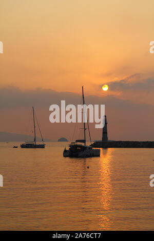 Seascape al tramonto. Faro sulla costa. Città balneare di Turgutreis e tramonti spettacolari Foto Stock