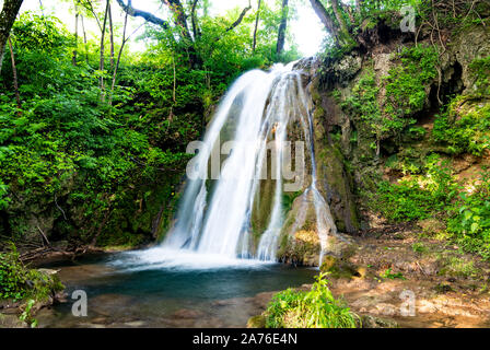 Belle cascate nel villaggio di Donji Taor, Taorska vrela. Piante verdi e moss bloom accanto all'acqua che scorre verso il basso lungo la cascata di rocce calcaree. Foto Stock