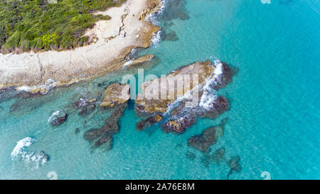 Vista aerea di formazioni rocciose in acque blu del Mare Adriatico, sulla pittoresca costa pugliese, vicino a Baia dei Turchi, Italia meridionale . Foto Stock