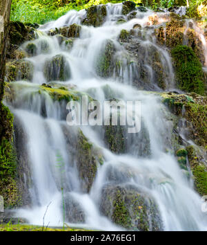 Belle cascate nel villaggio di Donji Taor, vicino a Valjevo, Serbia, Taorska vrela. Piante verdi e moss bloom accanto all'acqua che scorre verso il basso le rocce Foto Stock