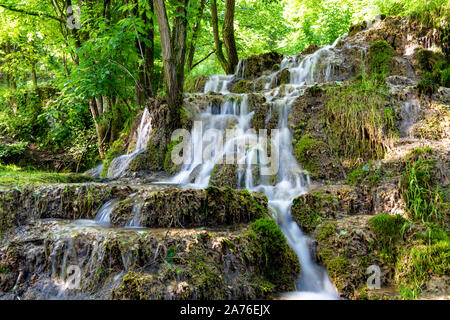 Belle cascate nel villaggio di Donji Taor, vicino a Valjevo, Serbia, Taorska vrela. Piante verdi e moss bloom accanto all'acqua che scorre verso il basso le rocce Foto Stock