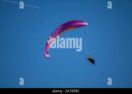 Parapendio su sky con uno sfondo con rivestimento a getto dietro con passeggeri a bordo Foto Stock