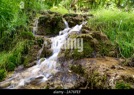 Belle cascate nel villaggio di Donji Taor, vicino a Valjevo, Serbia, Taorska vrela. Piante verdi e moss bloom accanto all'acqua che scorre verso il basso le rocce Foto Stock