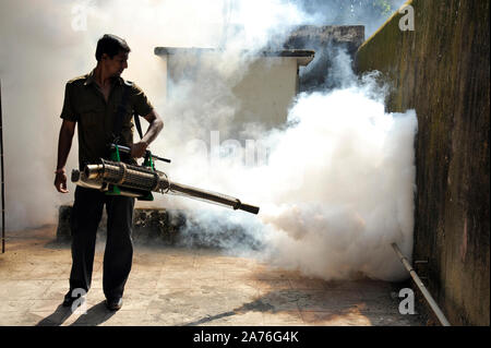 Mumbai, Maharashtra, India, Sud-est asiatico - Lavoratore appannamento area residenziale con insetticidi per uccidere aedes portatore del virus Dengue Foto Stock