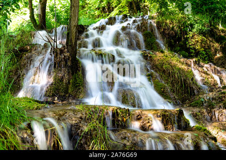 Belle cascate nel villaggio di Donji Taor, vicino a Valjevo, Serbia, Taorska vrela. Piante verdi e moss bloom accanto all'acqua che scorre verso il basso le rocce Foto Stock