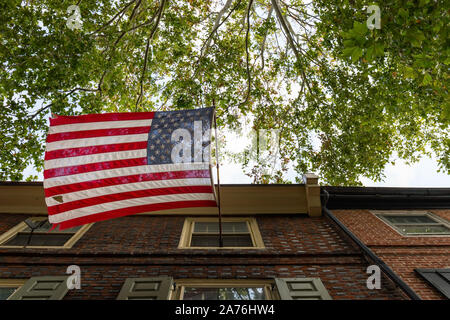 Un strappata noi bandiera come visto dalla strada che pende da una costruzione a Philadelphia, PA. Foto Stock