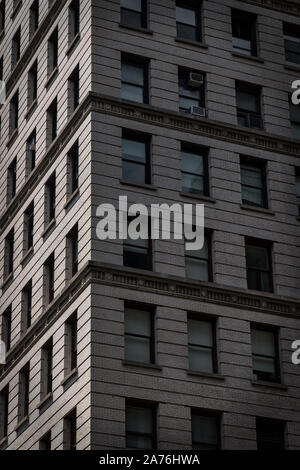 Il sole splende su un edificio ad angolo in New York City. Foto Stock