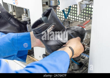 Formando la parte anteriore su una macchina speciale. Produzione di calzature. Foto Stock