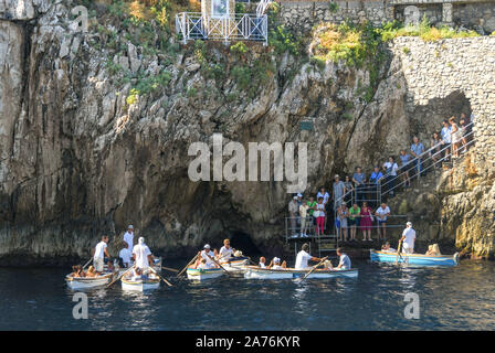 Isola di Capri - Agosto 2019: Persone in piccole barche a remi essendo remato da e per l'ingresso della "Grotta Azzurra" o "Grotta Azzurra" grotta Foto Stock